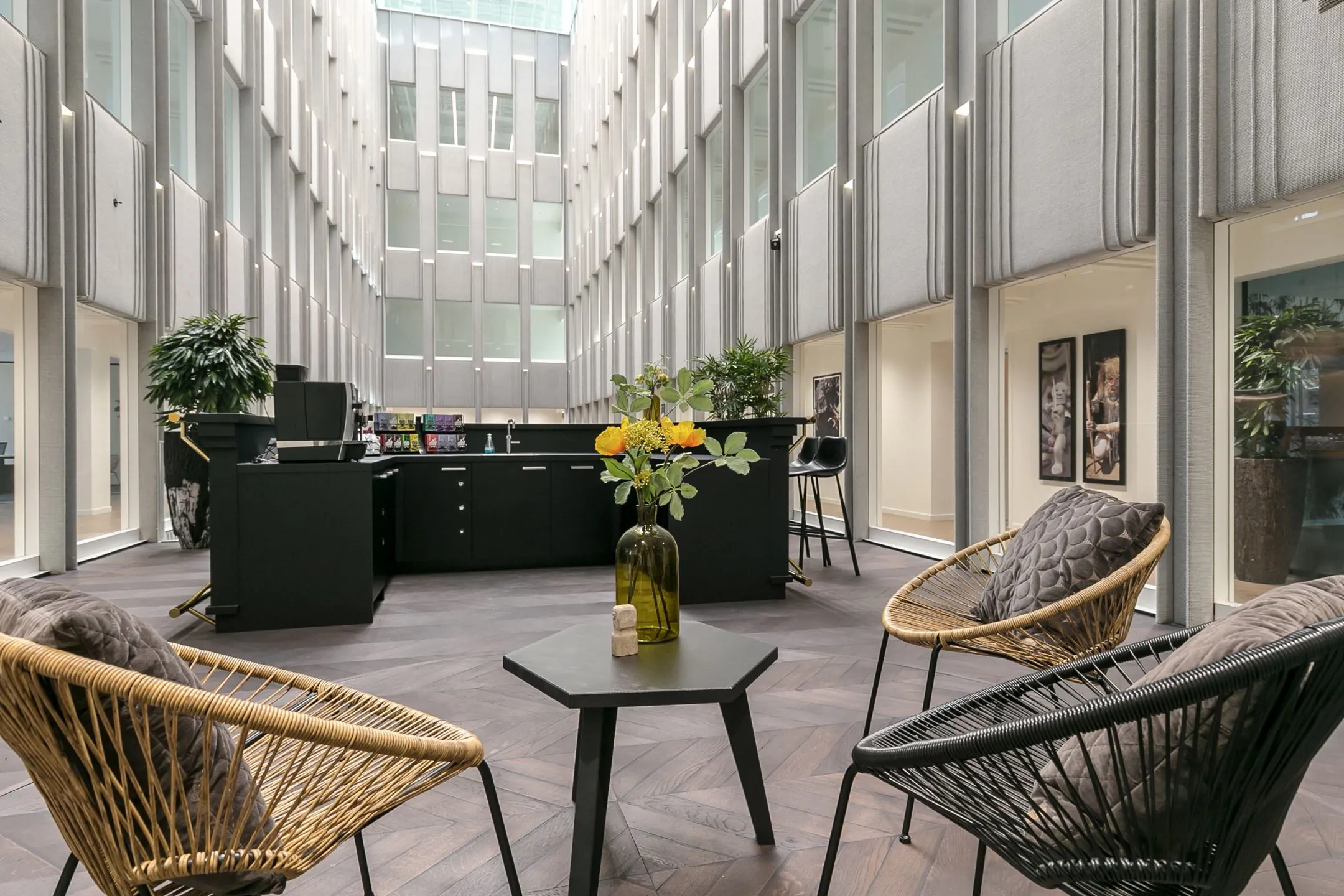 Moderne gemeenschappelijke ruimte met zithoeken en een koffiebar in kantoorgebouw Rotterdam Blaak 34.