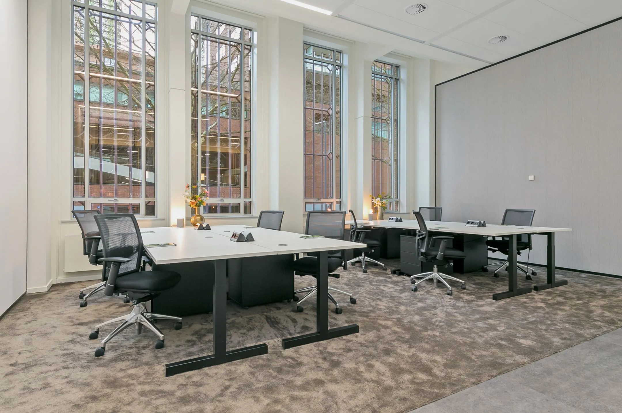 Moderne kantoorruimte met werkplekken en grote ramen aan de Blaak 34 in Rotterdam.