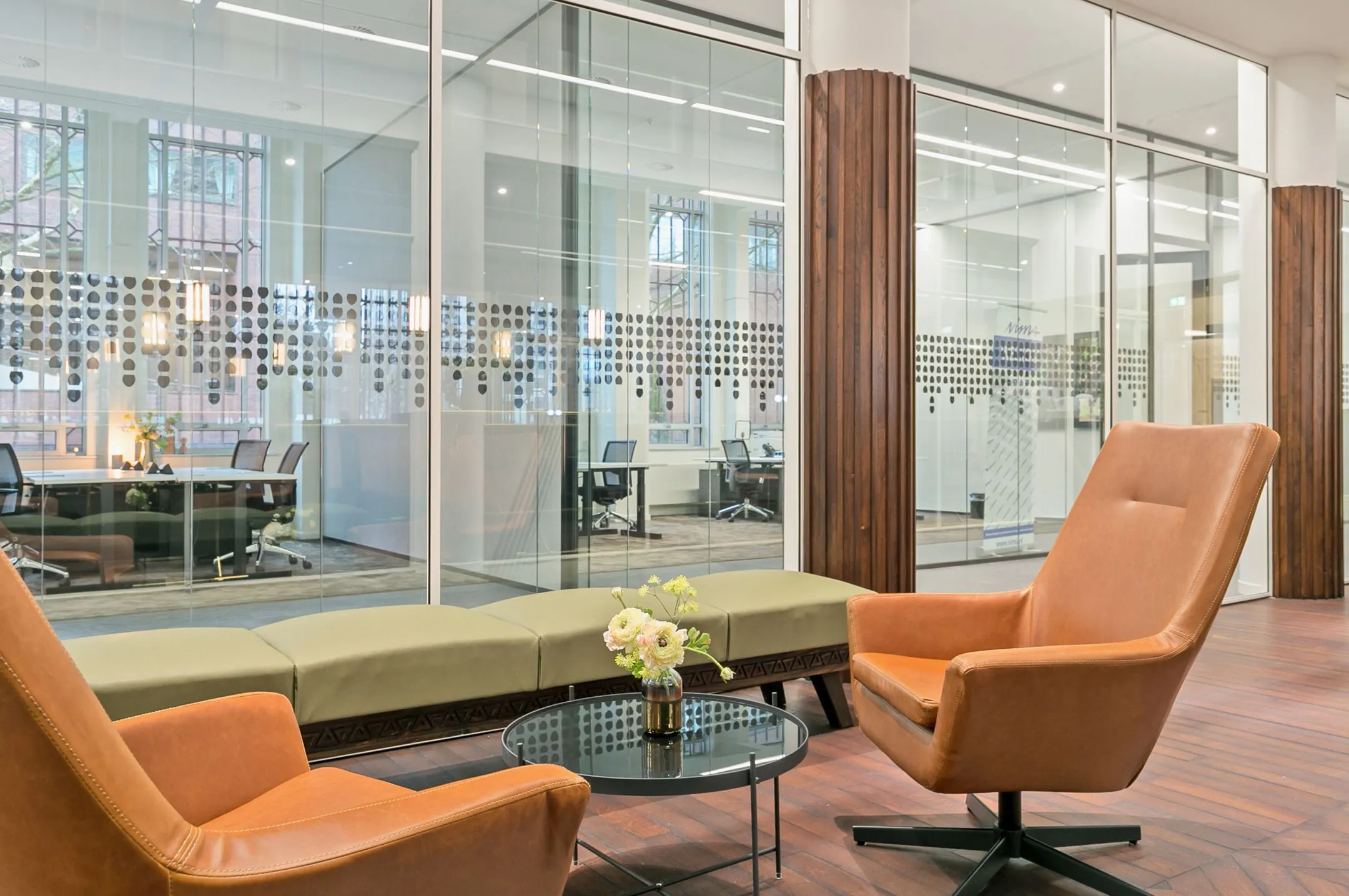 Moderne wachtruimte met leren fauteuils en glazen wanden in kantoorruimte aan Rotterdam Blaak 34.