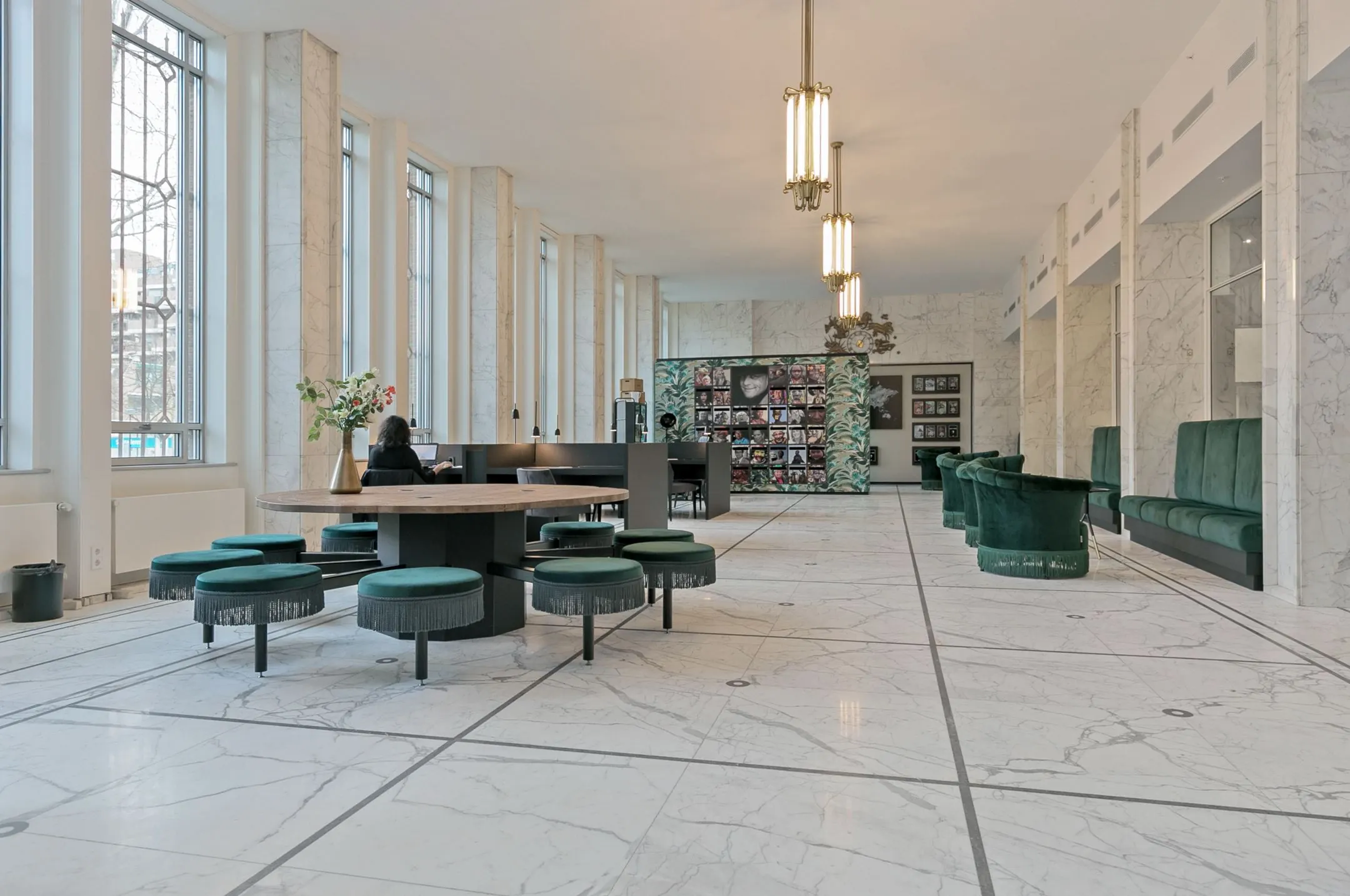 Moderne, lichte kantoorruimte aan de Blaak 34 in Rotterdam met marmeren vloer, groene zitmeubels en grote ramen.