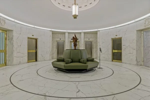 Ronde marmeren ontvangsthal met groene zitbank en liften in kantoorgebouw Blaak 34 in Rotterdam.