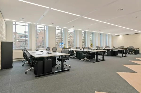 Moderne kantoorruimte te huur aan de Blaak 34 in Rotterdam met werkplekken, bureaustoelen en grote ramen voor veel daglicht.