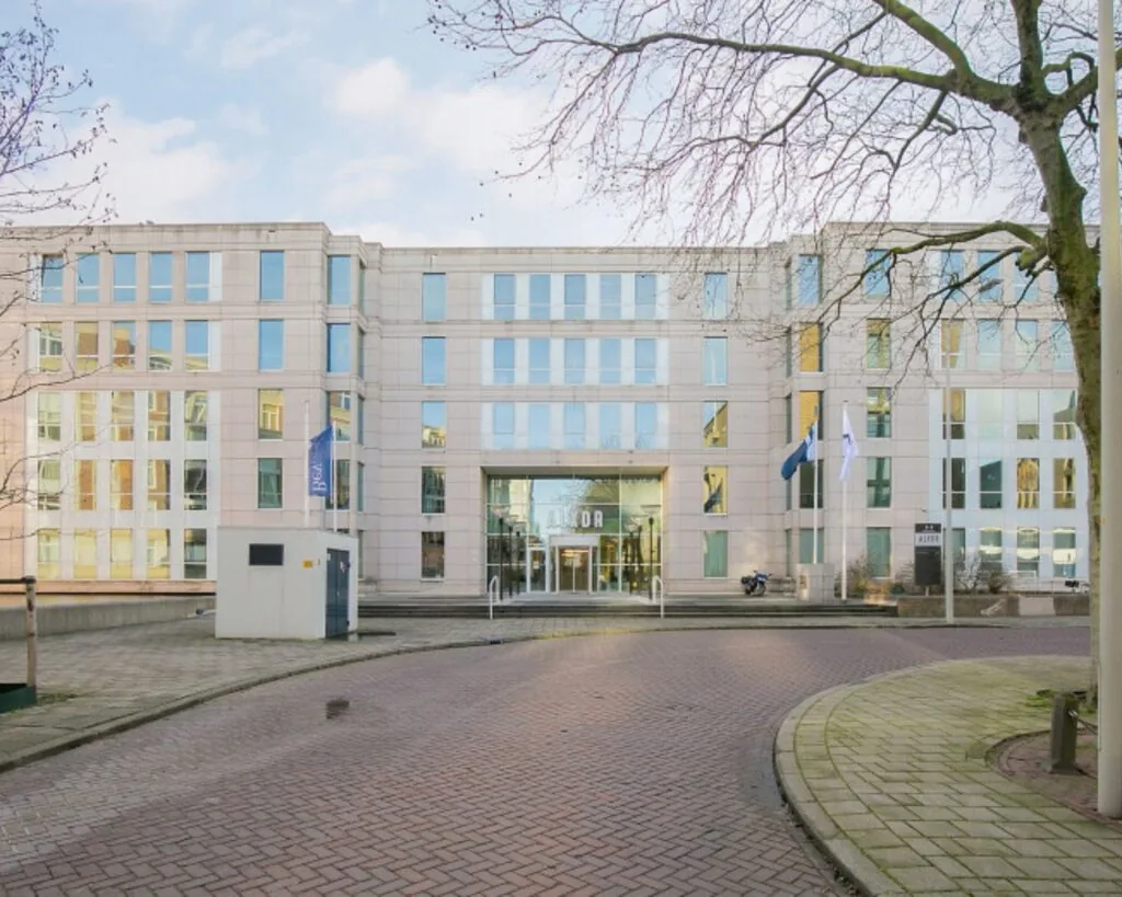 Moderne kantoorruimte aan het Alexanderveld 5 in Den Haag met glazen gevel en meerdere vlaggen bij de entree.
