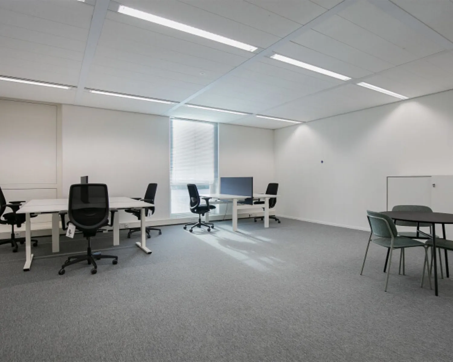 Moderne kantoorruimte met bureaus, stoelen en werkplekken aan het Alexanderveld 5-15 in Den Haag.