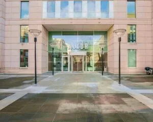 Ingang van het kantoorgebouw aan Alexanderveld 5 in Den Haag met grote glazen entree en de letters "ALXDR" boven de deur.