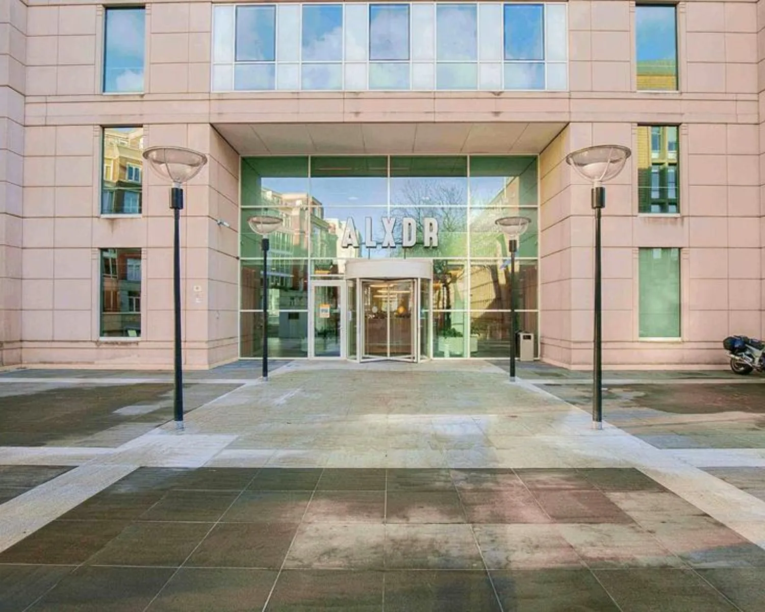 Ingang van het kantoorgebouw aan Alexanderveld 5 in Den Haag met grote glazen entree en de letters "ALXDR" boven de deur.