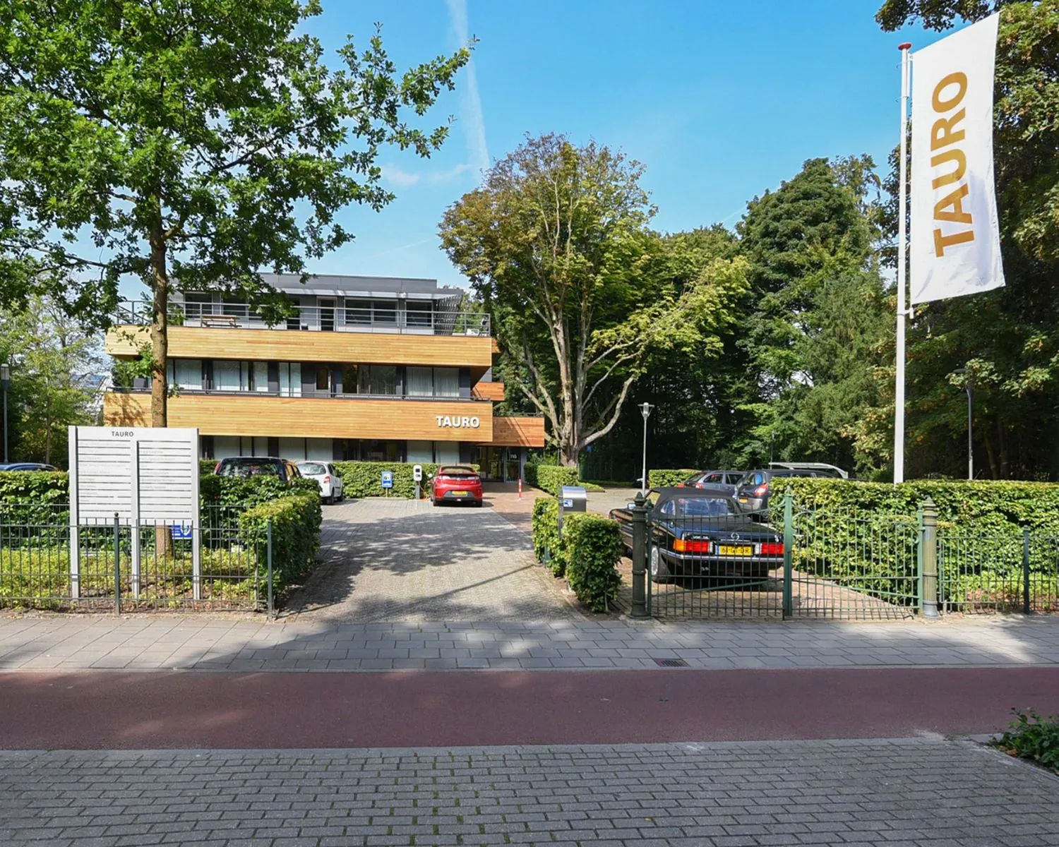 Kantoorpand van Tauro aan de Herenweg 15 in Heemstede met parkeerplaatsen en groenvoorziening.