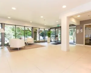 Moderne en lichte entreehal van een kantoorpand aan de Herenweg 15 in Heemstede met zithoek en glazen gevel.