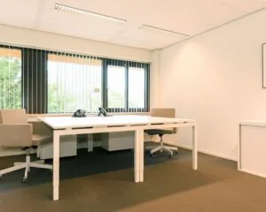 Lichte en moderne kantoorruimte met twee bureaus en grote ramen aan de Herenweg 15 in Heemstede.