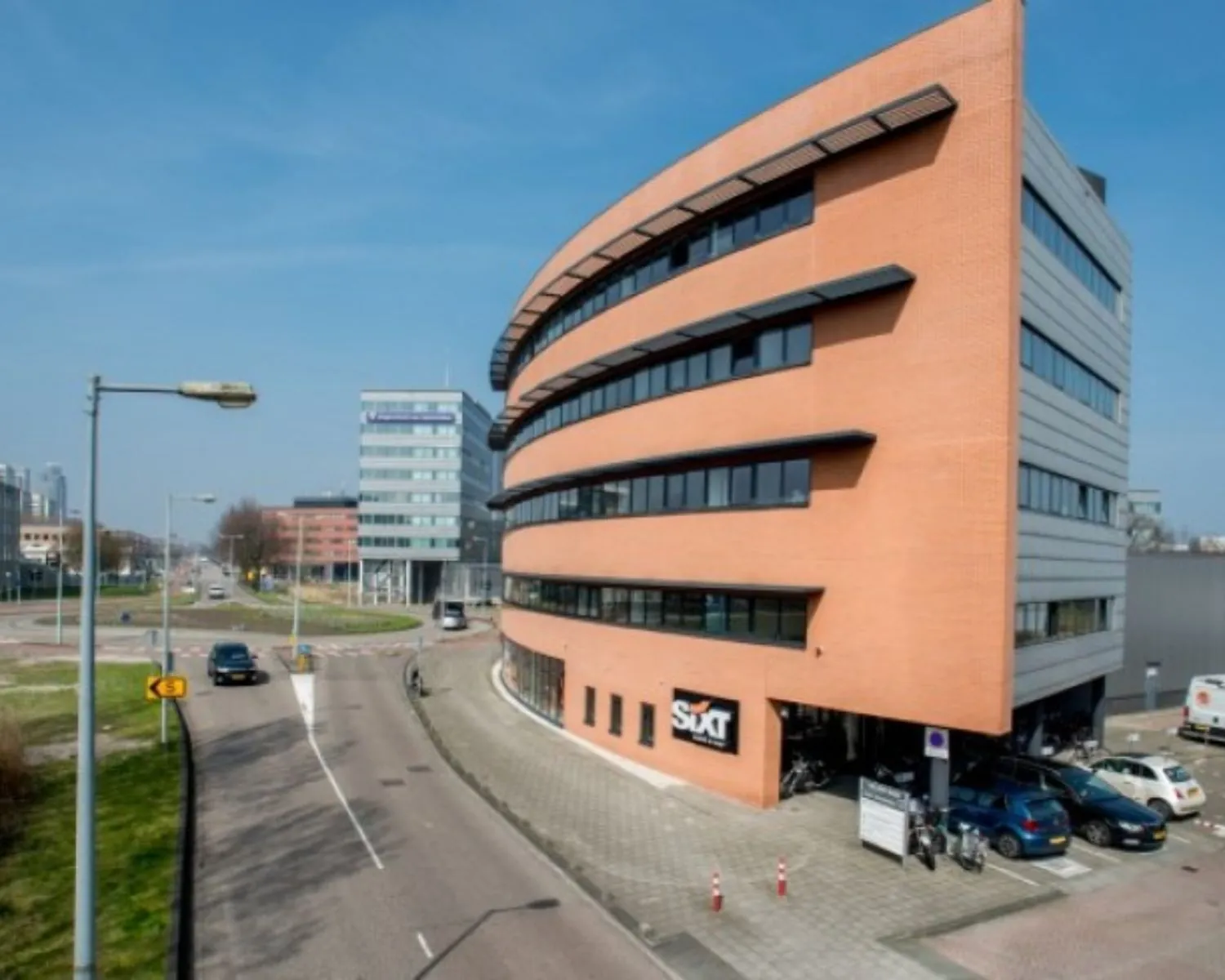 Modern kantoorgebouw aan de Joop Geesinkweg 125 met Sixt-verhuurlocatie op de begane grond.