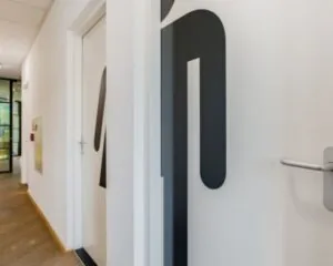Gang met toiletdeuren in een kantoorruimte aan de Joop Geesinkweg 125.
