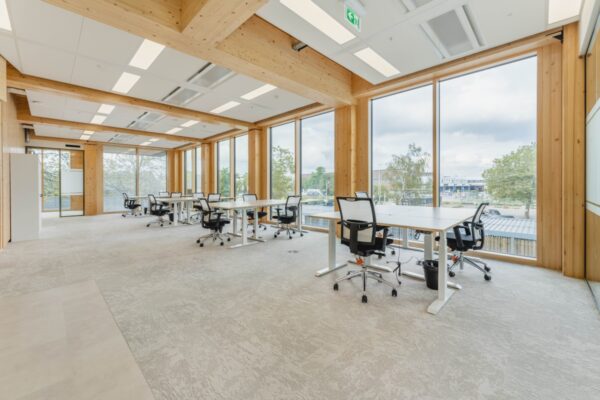 Moderne kantoorruimte met houten details en grote ramen aan de Basisweg in Amsterdam.