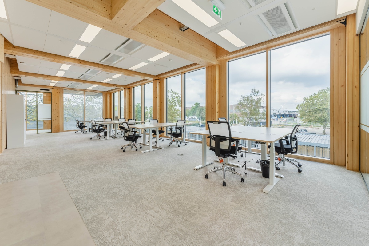 Moderne kantoorruimte met houten details en grote ramen aan de Basisweg in Amsterdam.