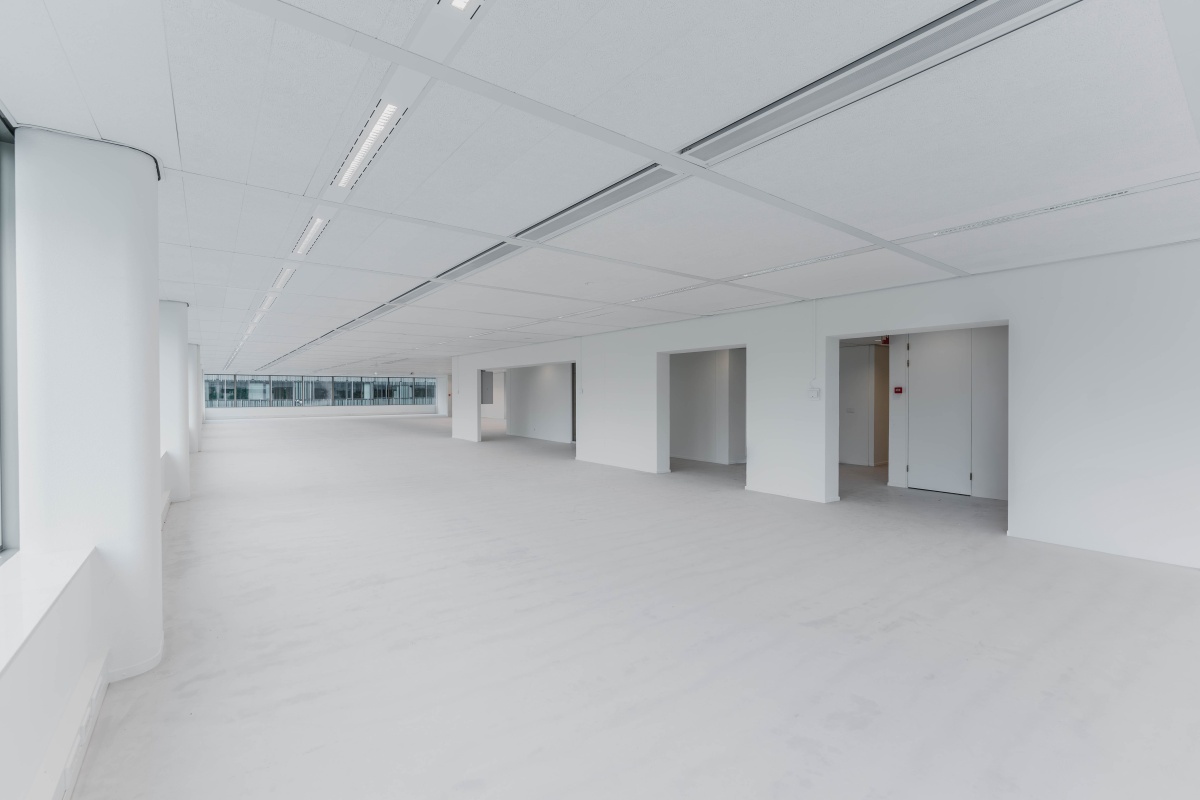 Lichte, open kantoorruimte met grote ramen aan de Herikerbergweg in Amsterdam.