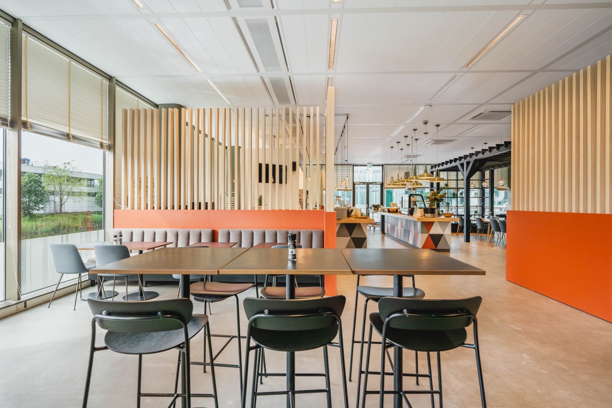 Een moderne kantoorruimte met stoelen en tafels aan de Herikerbergweg in Amsterdam.