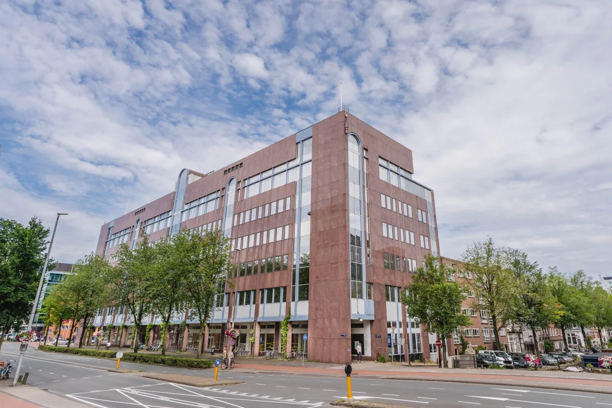 Modern kantoorgebouw aan de Weesperstraat 107-121 in Amsterdam met grote ramen en een roodbruine gevel.