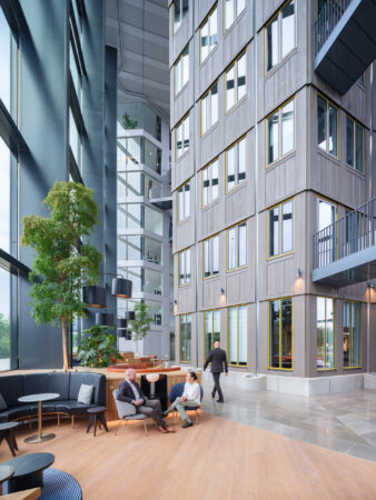 Moderne en lichte kantoorruimte aan het Burgerweeshuispad 301 in Amsterdam met zithoek, hoge ramen en groene planten.