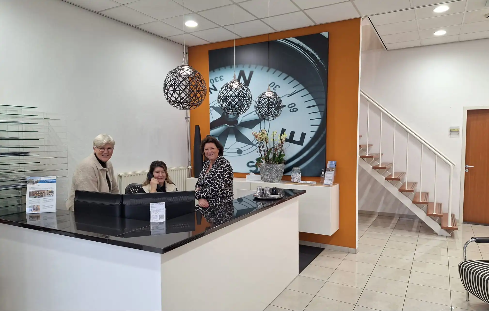 Receptiebalie met drie lachende personen in de kantoorruimte aan de Leeghwaterstraat 25 in Reeuwijk.