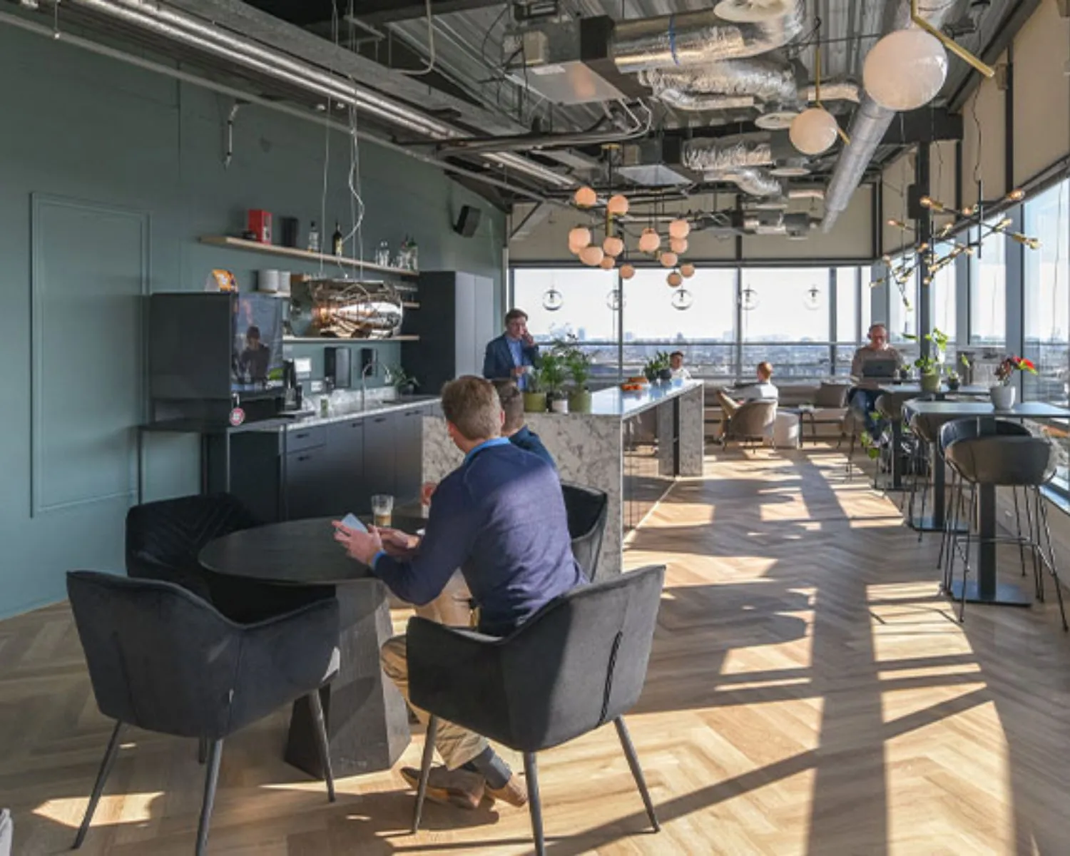 Moderne en lichte kantoorruimte aan het Bos en Lommerplein in Amsterdam met open werkplekken, zithoeken en een koffiebar.