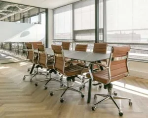Moderne vergaderruimte met leren bureaustoelen en grote ramen in een kantoor aan het Bos en Lommerplein in Amsterdam.