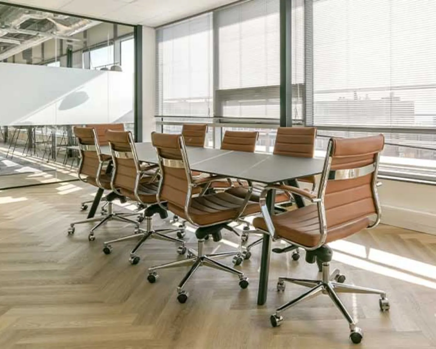 Moderne vergaderruimte met leren bureaustoelen en grote ramen in een kantoor aan het Bos en Lommerplein in Amsterdam.