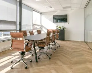 Moderne vergaderruimte met leren bureaustoelen en grote ramen in een kantoor aan het Bos en Lommerplein in Amsterdam.