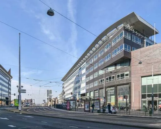 Modern kantoorgebouw aan het Bos en Lommerplein in Amsterdam met tramhalte en bushokje op de voorgrond.