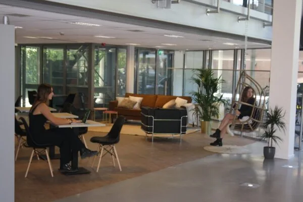 Moderne kantoorruimte aan de Bronsteeweg 10 in Heemstede met zithoeken, werkplekken en een hangstoel.