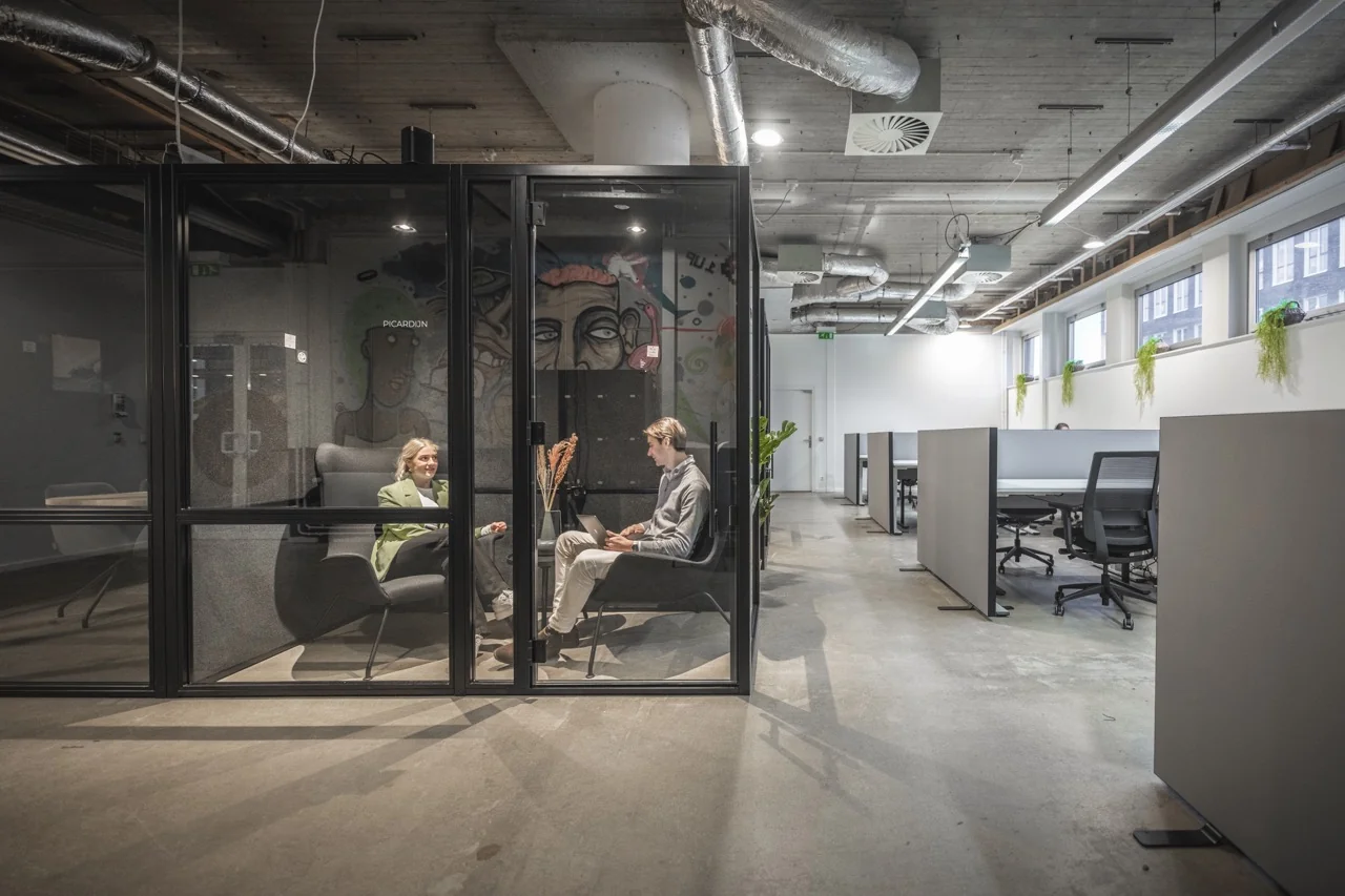 Moderne kantoorruimte aan de Brouwerijstraat 1 in Enschede met glazen vergaderruimte en open werkplekken.