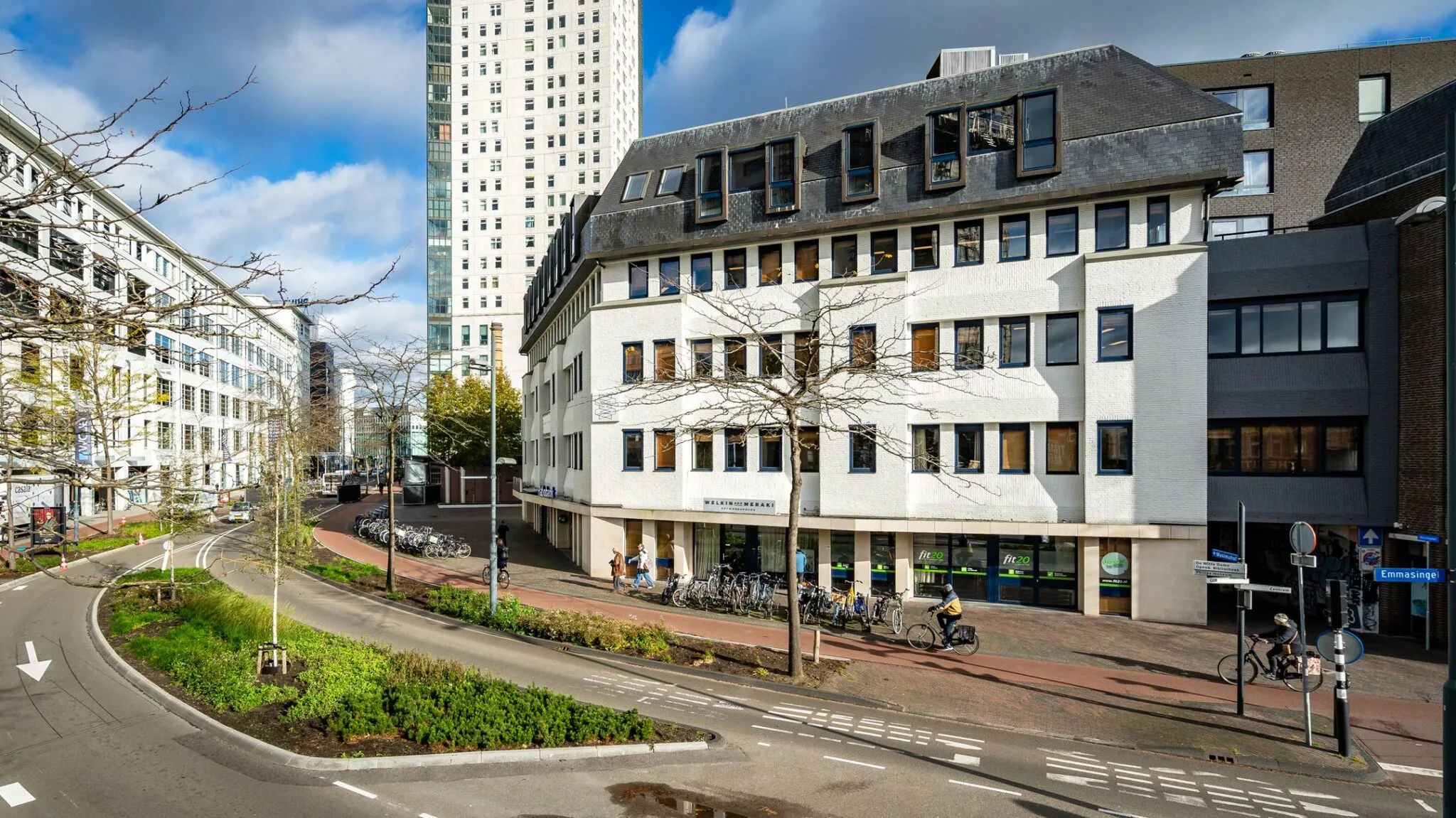 Hoekpand met kantoorruimtes aan de Emmasingel 33 in Eindhoven, gezien vanaf de straat met fietsers en omliggende bebouwing.