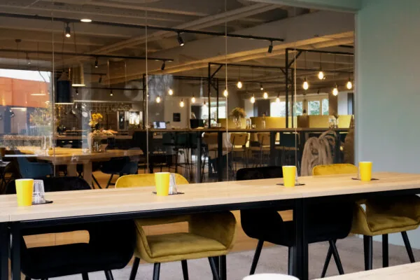 Moderne en sfeervolle kantoorruimte aan Flight Forum 760 in Eindhoven met glazen wanden en kleurrijke zitplaatsen.