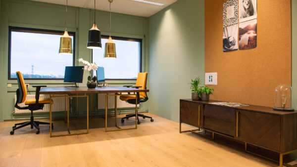 Modern ingerichte kantoorruimte met twee werkplekken, gele bureaustoelen en grote ramen in Flight Forum 760 in Eindhoven.