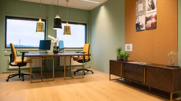 Modern ingerichte kantoorruimte met twee werkplekken, gele bureaustoelen en grote ramen in Flight Forum 760 in Eindhoven.