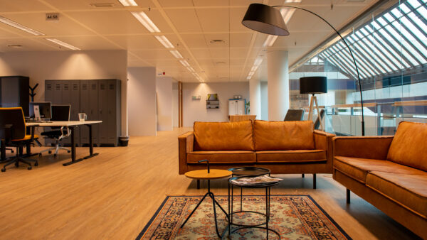 Moderne en sfeervolle kantoorruimte in Flight Forum 760 in Eindhoven met zithoek, bureaus en grote ramen.