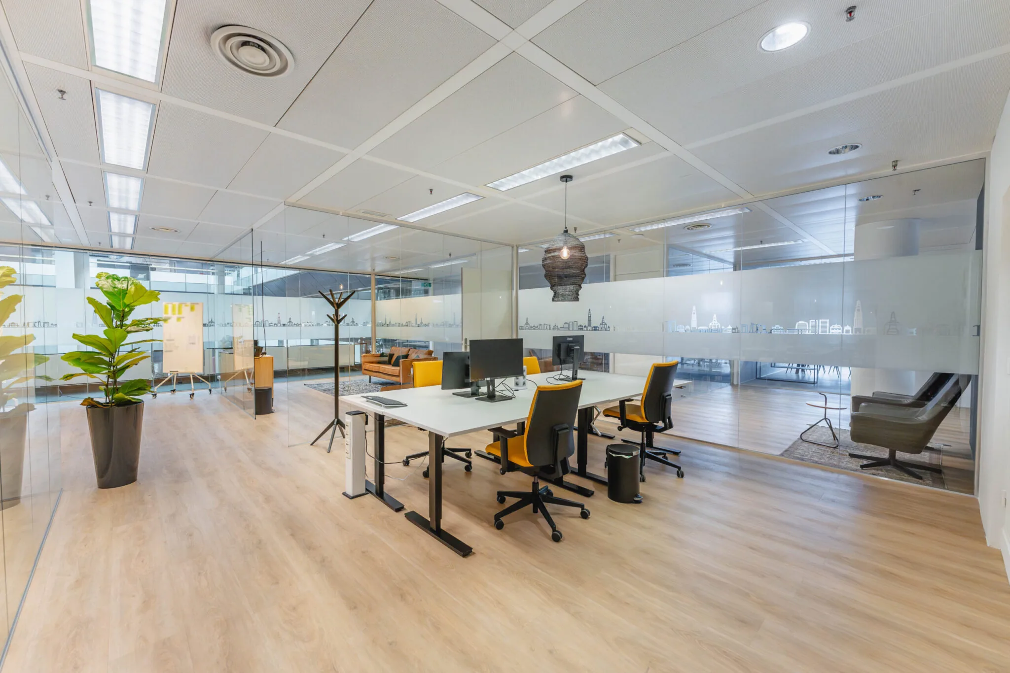 Moderne kantoorruimte met glazen wanden, werkplekken en een loungegedeelte in Flight Forum 760, Eindhoven.