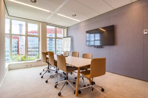 Moderne vergaderruimte met zes stoelen, een flatscreen en uitzicht op kantoren aan de George Hintzenweg 89 in Rotterdam.