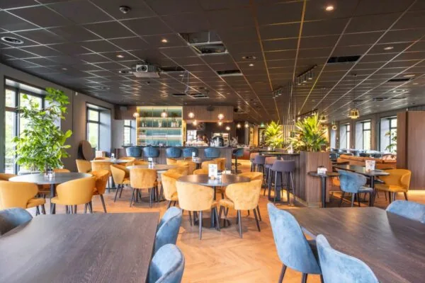 Moderne, sfeervolle horecaruimte met kleurrijke zitplaatsen en bar in kantoorlocatie aan George Hintzenweg 89 in Rotterdam.