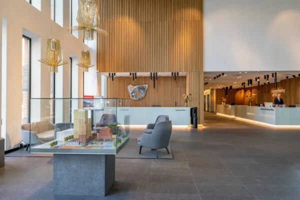 Moderne ontvangsthal van Symphony Offices aan het Gustav Mahlerplein 109 in Amsterdam met zitgedeelte en maquette van het kantoorgebouw.