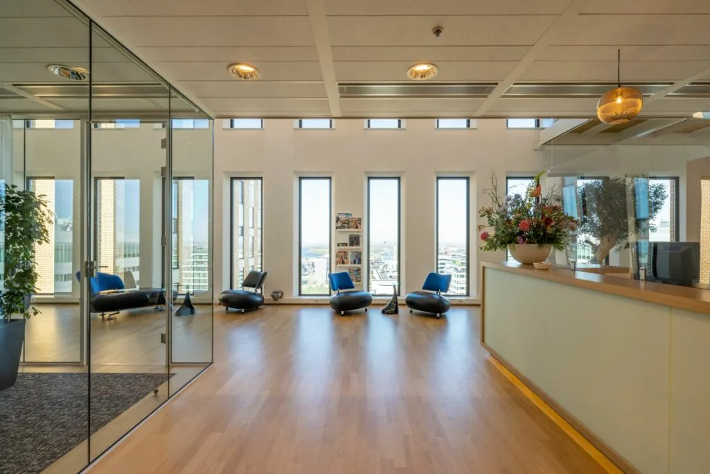 Moderne kantoorruimte met zithoek, receptiebalie en grote ramen aan het Gustav Mahlerplein 109 in Amsterdam.