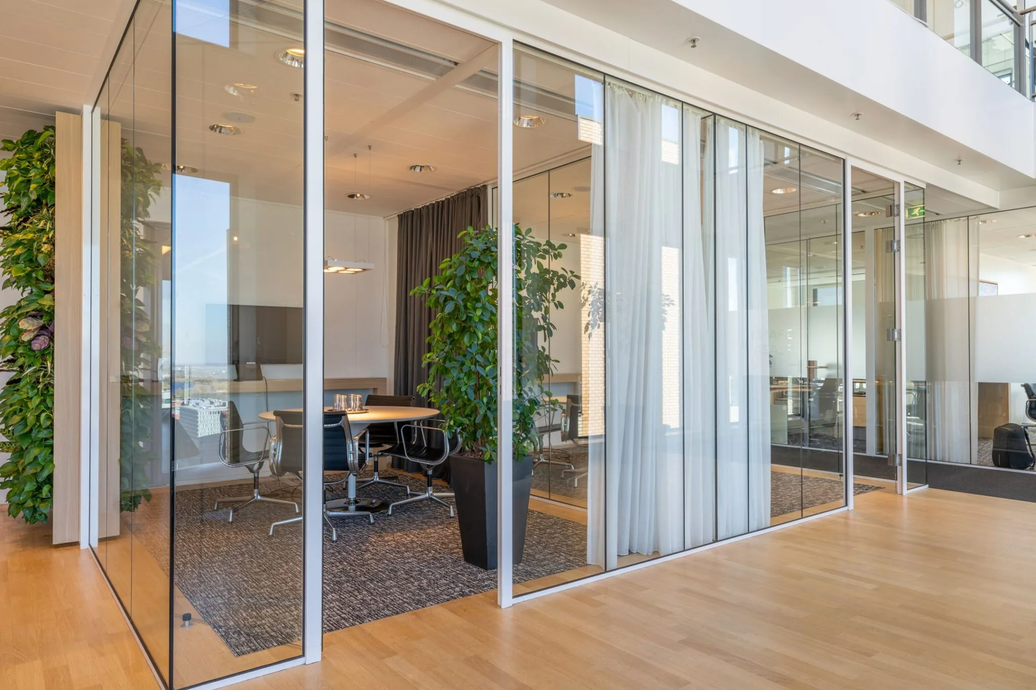 Moderne glazen vergaderruimte met planten en een uitzicht, gelegen aan het Gustav Mahlerplein 109 in Amsterdam.