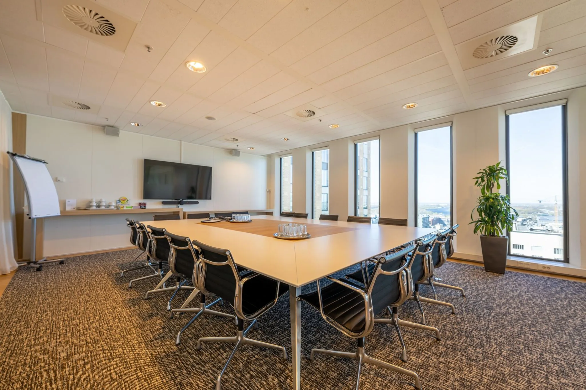 Moderne vergaderruimte met grote tafel en panoramisch uitzicht op de Zuidas vanaf Gustav Mahlerplein 109 in Amsterdam.