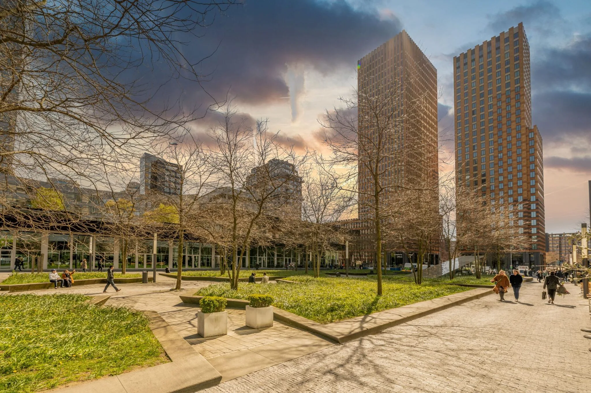 Moderne kantoorgebouwen aan het Gustav Mahlerplein in Amsterdam met een groen stadspark op de voorgrond.