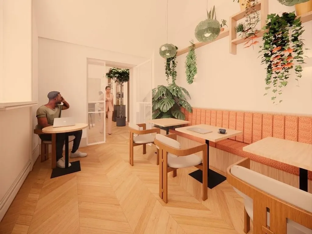 Moderne, lichte kantoorruimte aan de Keizersgracht 264 in Amsterdam met houten vloer, zitplekken, laptops en hangende planten.