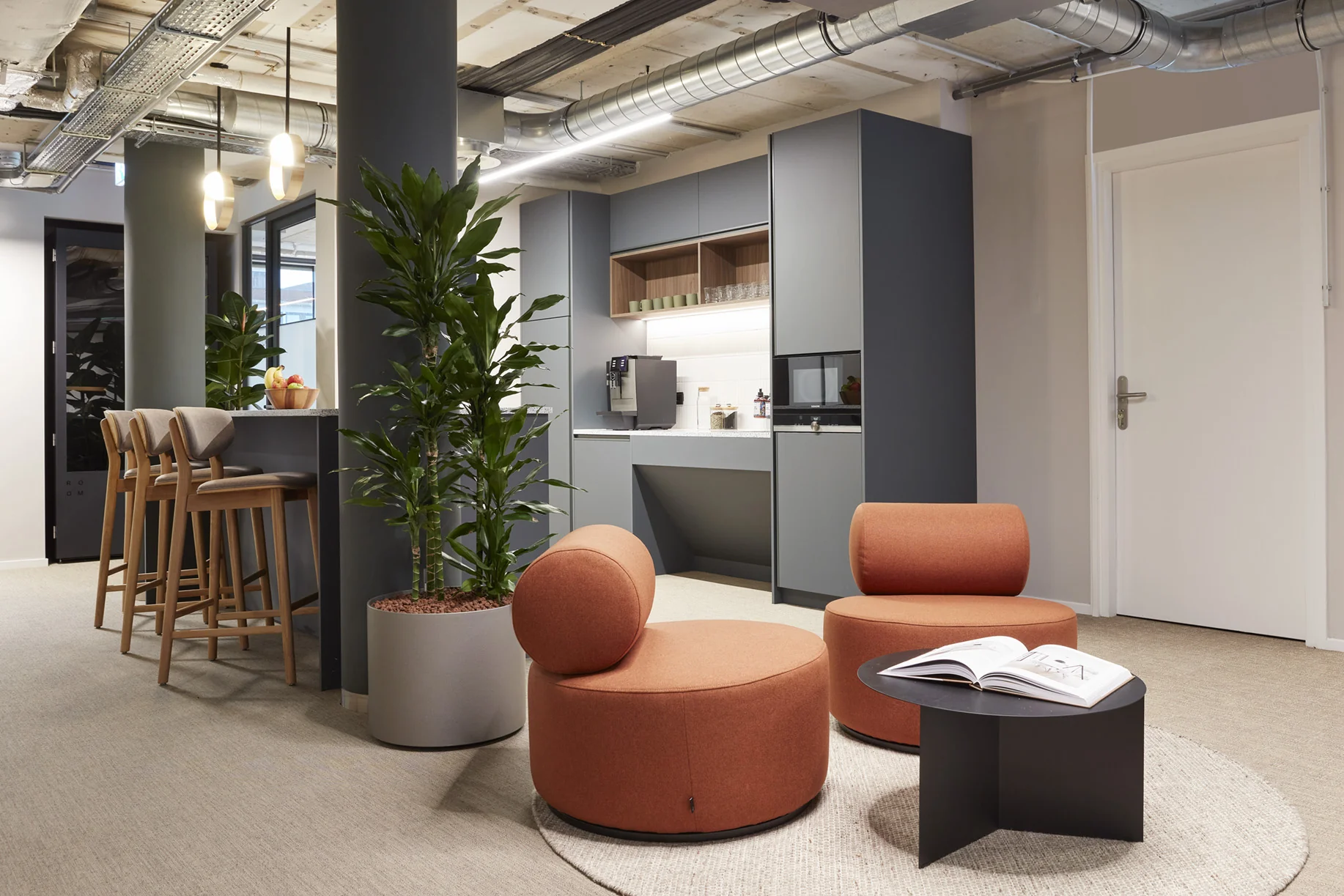 Moderne kantoorruimte aan de Koninginnegracht 10 in Den Haag met zithoek, koffiecorner en strakke, industriële afwerking.