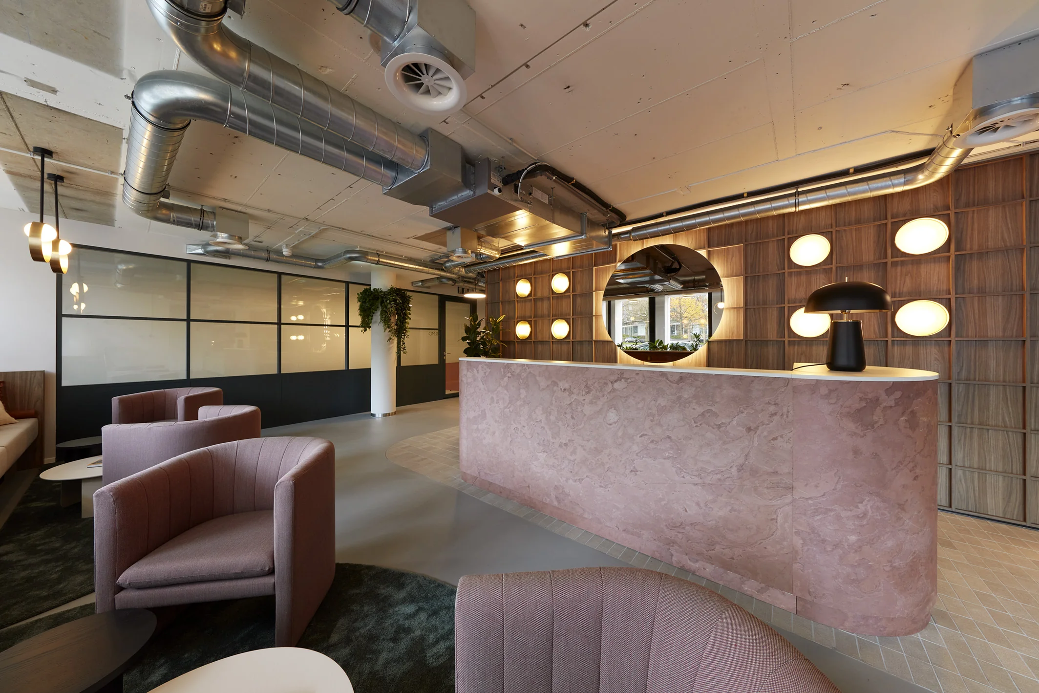 Moderne kantoorruimte aan de Koninginnegracht 10 in Den Haag met een stijlvolle ontvangstbalie en loungehoek.