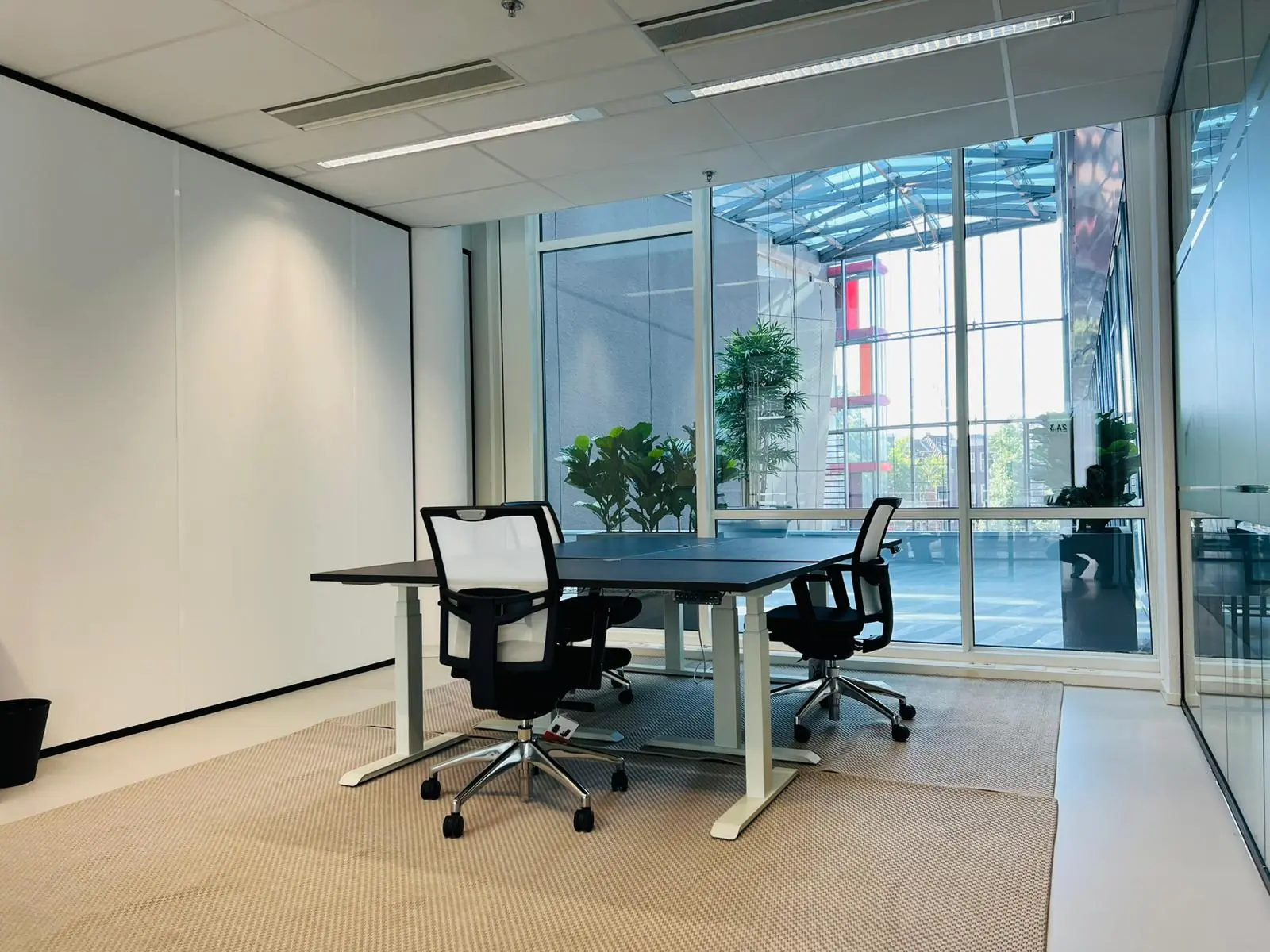 Moderne kantoorruimte aan het Kruisplein 480 in Rotterdam met glazen wanden, bureaus en bureaustoelen.