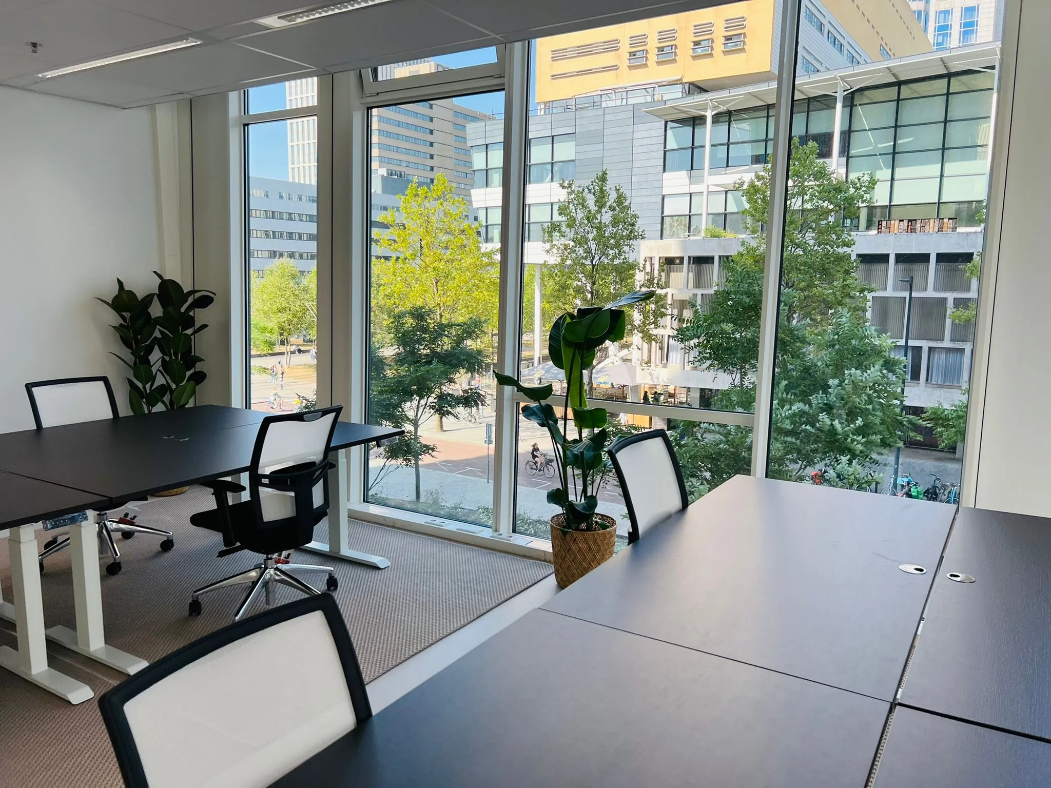 Moderne kantoorruimte met grote ramen en uitzicht op het Kruisplein in Rotterdam.