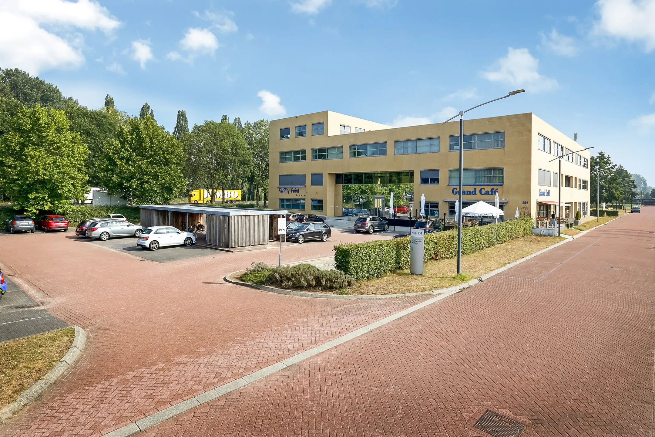 Modern kantoorgebouw aan de Meander 251 in Arnhem met parkeerplaats en grand café aan de voorzijde.