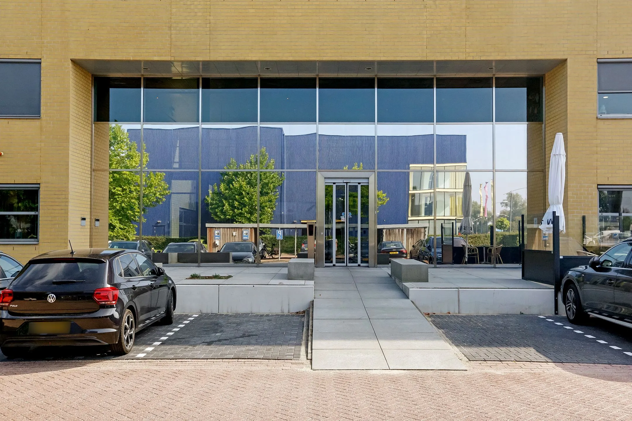 Entree van het kantoorpand aan Meander 251 in Arnhem met grote glazen gevel en parkeergelegenheid.