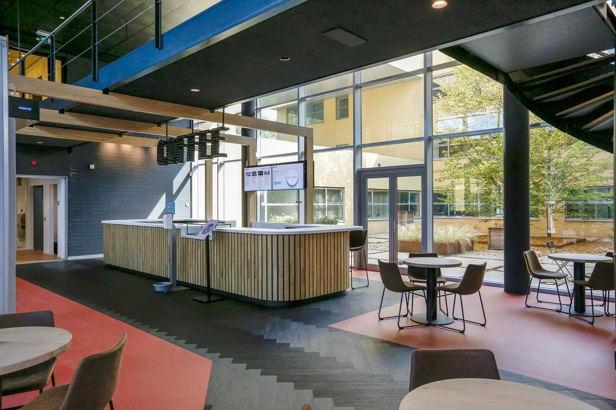 Moderne ontvangstruimte met koffiebar en zitgedeelte in kantoorpand Meander 251 in Arnhem.